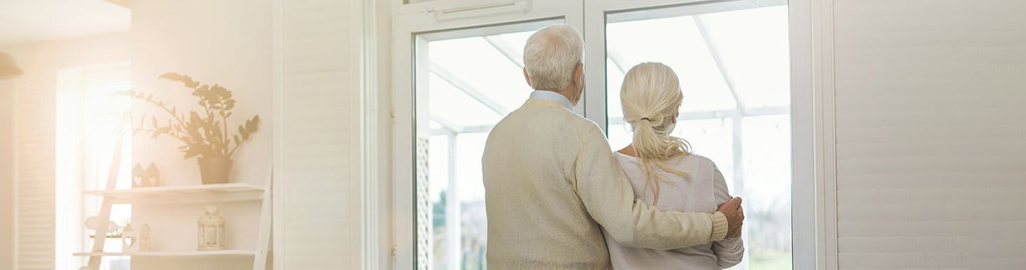 Älteres Ehepaar schaut aus dem Fenster