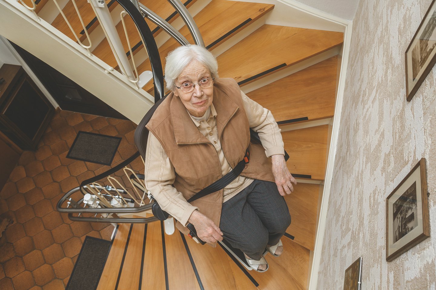 Frau im Stehlift fährt die Treppe hoch