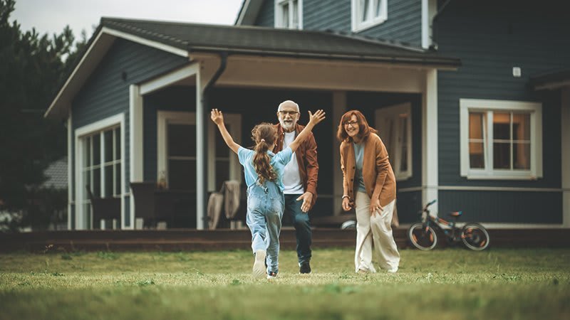 Enkelin läuft auf Großeltern vor deren Haus zu