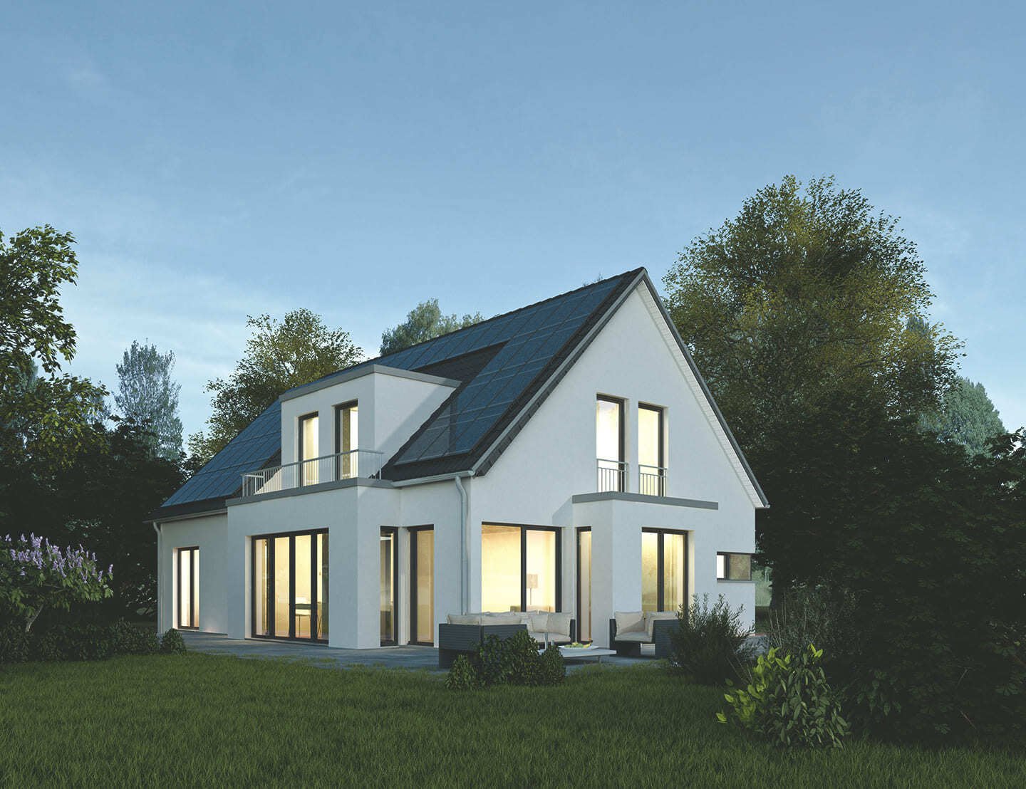 Ein Einfamilienhaus mit einer Solaranlage auf dem Dach am Abend, im Haus ist Licht an