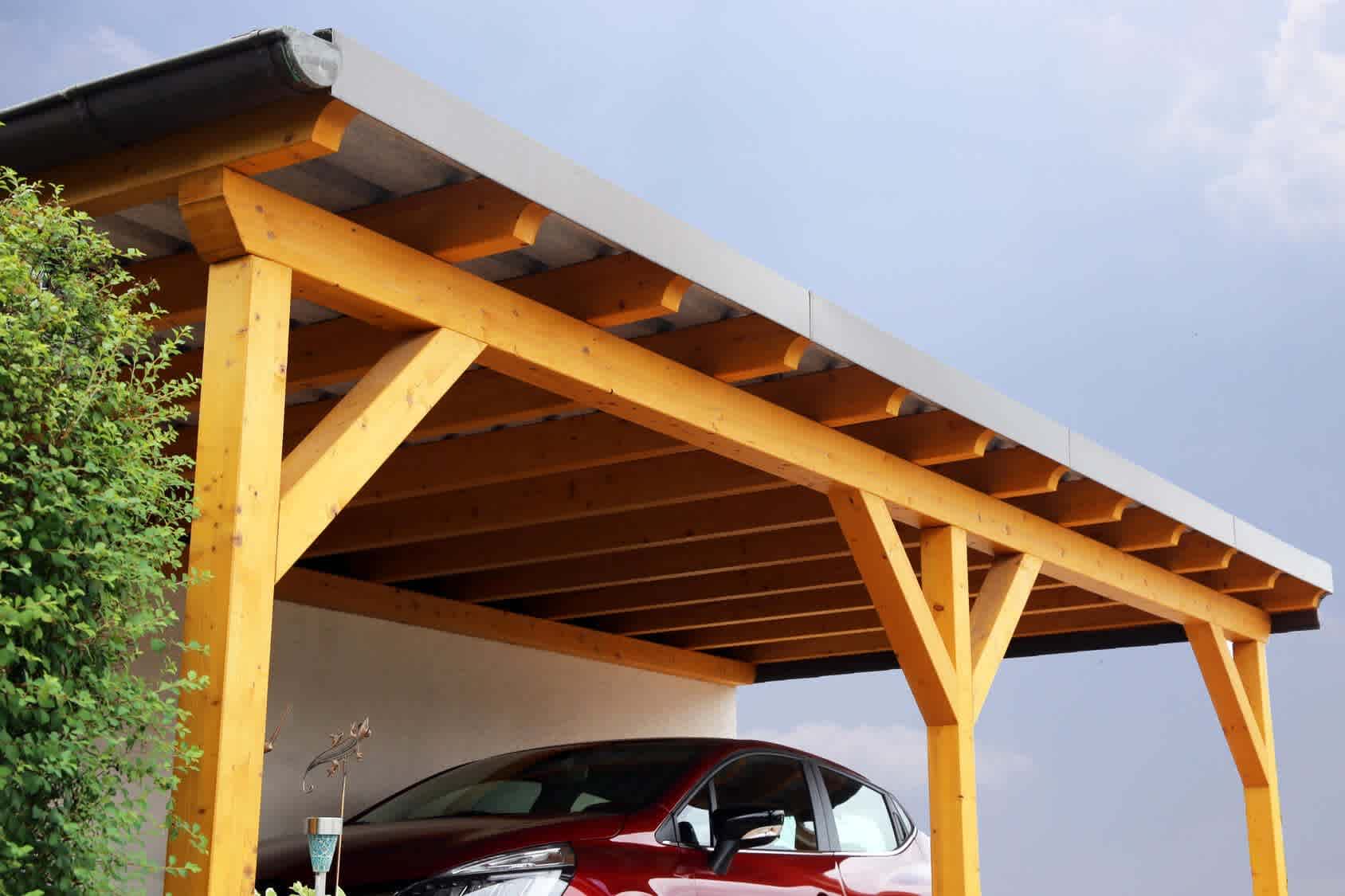 Auto steht unter dem Dach eines Holz-Carports