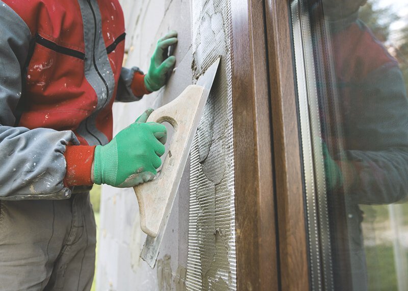 Handwerker verputzt Fassade