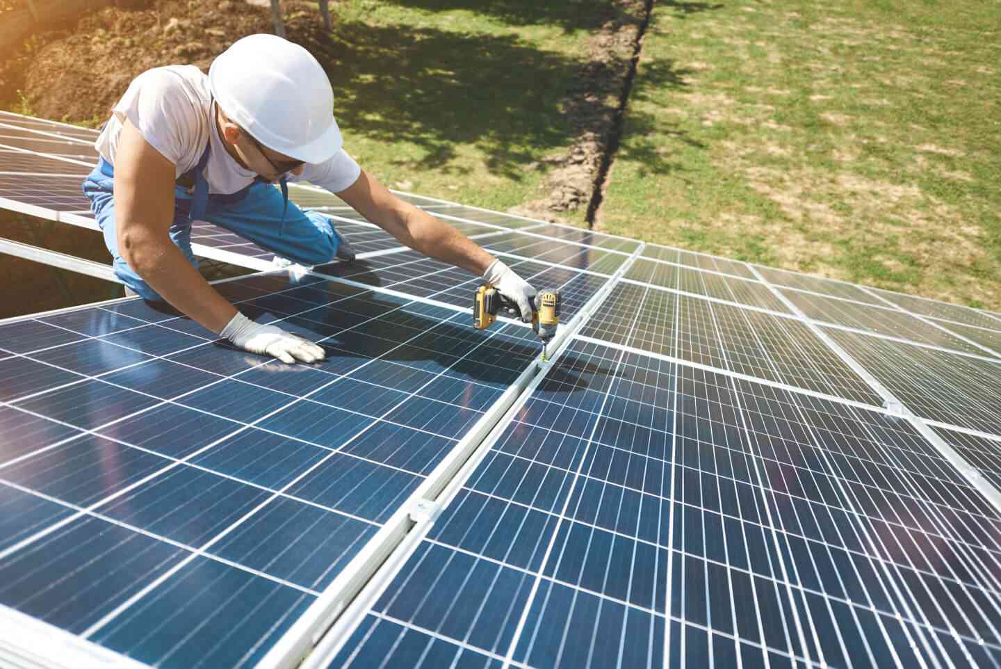 Handwerker installiert Solarzellen auf Hausdach