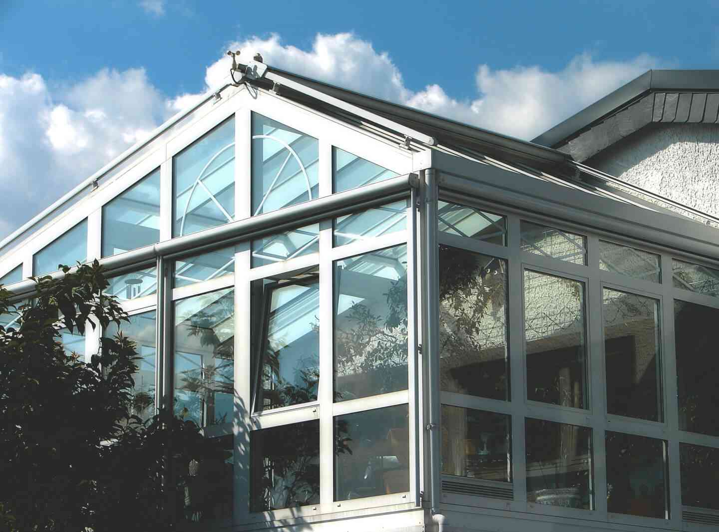 Wintergarten mit weißen Rahmen und großen Fensterfronten