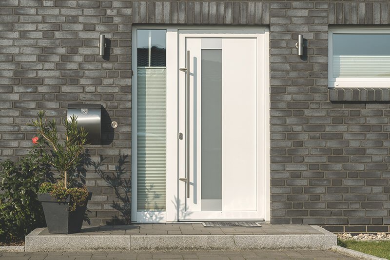 weiße Haustür aus Kunststoff mit Glaseinsatz und Seitenteil