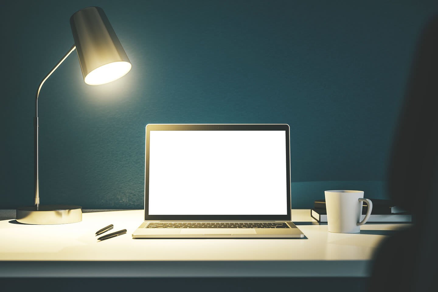 Schreibtisch mit Laptop, Lampe und Tasse
