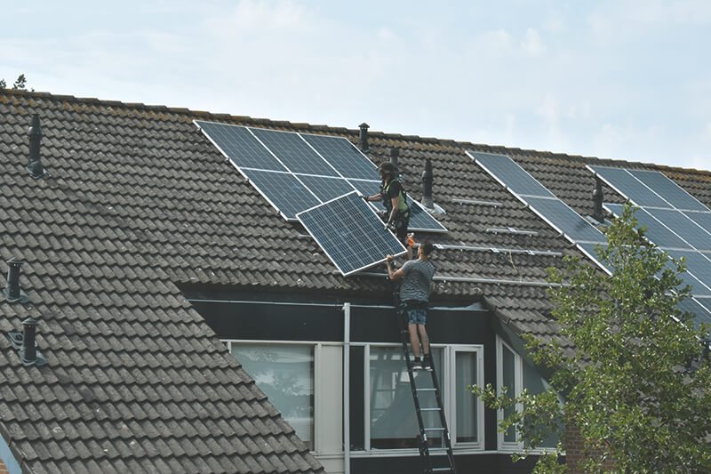 Zwei Leute stehen auf Dach mit Solaranlage