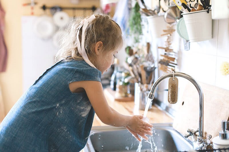 Kind wäscht sich Hände am Waschbecken